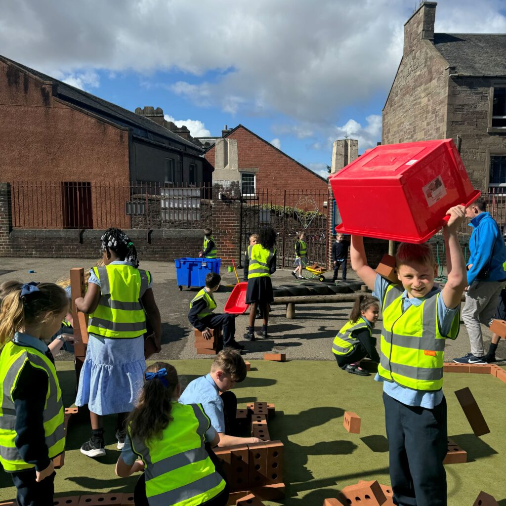 Kids playing in playground with bricks.
